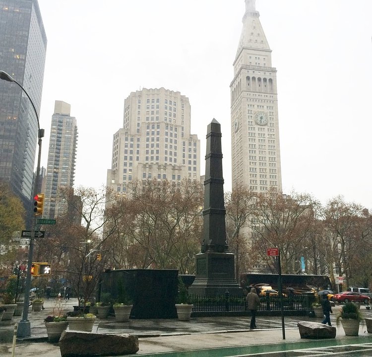 The monument sits along Madison Square Park, between Broadway and 5th Ave