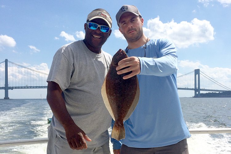 A pair of locals show off their catch from the deck of the Capitol Princess in New York Harbor.