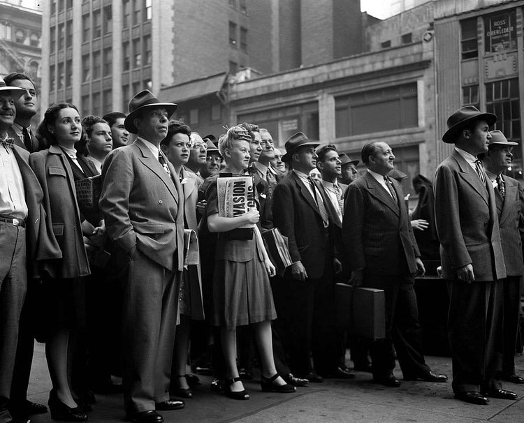 People gather in Times Square to watch the news ticker on the New York Times building
