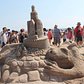 A fearsome dragon appears to be protecting (Or ready to swallow) this sand castle.