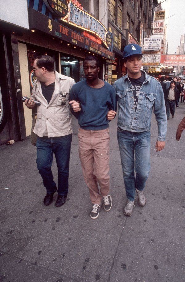 Sex wasn't the only trade of Times Square: the rise of crack-cocaine and the ability to operate on the street made the area a haven for drugs. In the above photograph, an undercover cop leads a man who's been arrested for selling crack in 1986.
