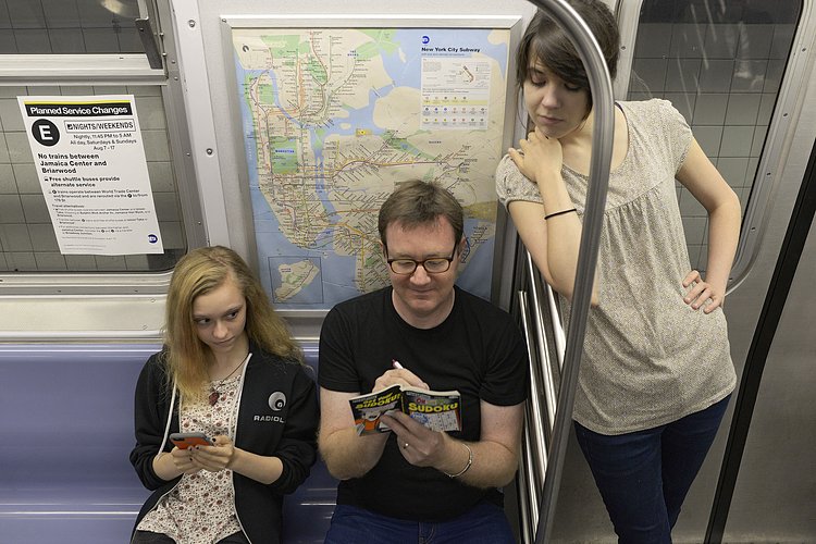 Man Playing Sudoku on Subway While Women Look Over His Shoulder | You can use this photo for non-commercial purposes if you give credit, under this <a href="https://creativecommons.org/licenses/by-nc/3.0/us/" rel="nofollow">Creative Commons license</a>. For-profit media organizations also may use this, but as editorial content only (as illustrations for stories, for example, but not as advertising). Credit must read: Richard Yeh / WNYC

We'd love to know if you're using this photo - send us an email (jkeefe@wnyc.org)!