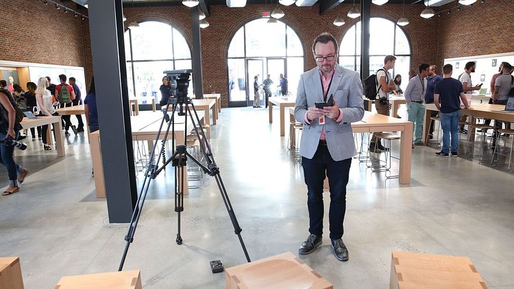 The giant screen and communal seating are at the far end of the main show floor.