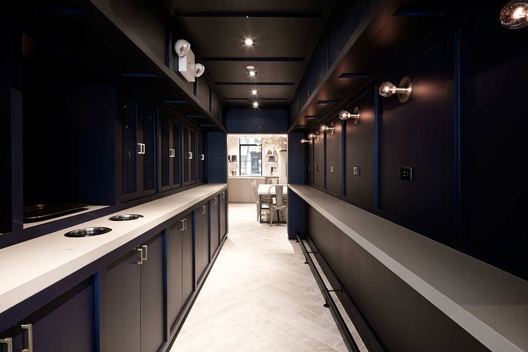 The connecting passageway is equipped with standing ledges and wall outlets — the only ones in the entire space.