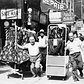 Men pulling racks of clothing on busy sidewalk in Garment District, New York City