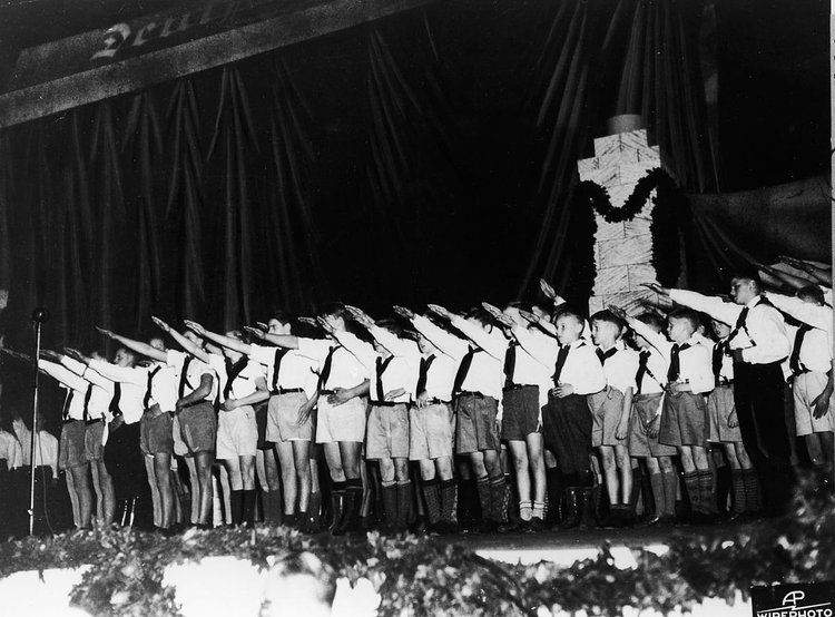 Boys in uniform salute during a pro-Nazi rally.