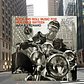 JACK E. LEONARD: ROCK AND ROLL MUSIC FOR KIDS OVER SIXTEEN (Vic, 1956). . .Location: The northeast corner of 56th Street and 7th Avenue, NYC, looking west. (I.e. next to the southwest corner of Carnegie Hall.). . . The pointed building in the upper right was the Broadway Tabernacle at the northeast corner of Broadway and 56th Street.. . Thanks to Chung Wong for figuring out the location and to Anne Raso for the album suggestion.. .Leonard was an American comedian and actor who made frequent appearances on television variety and game shows in the 50's and 60's.