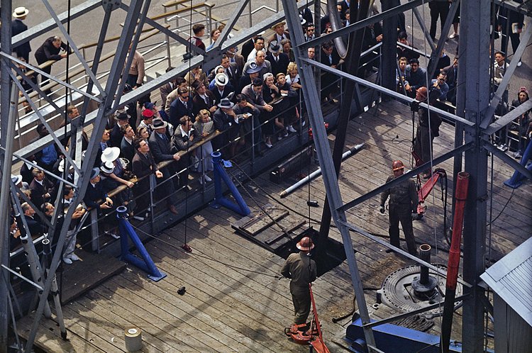 Visitors watch a working oil derrick at the petroleum exhibit.