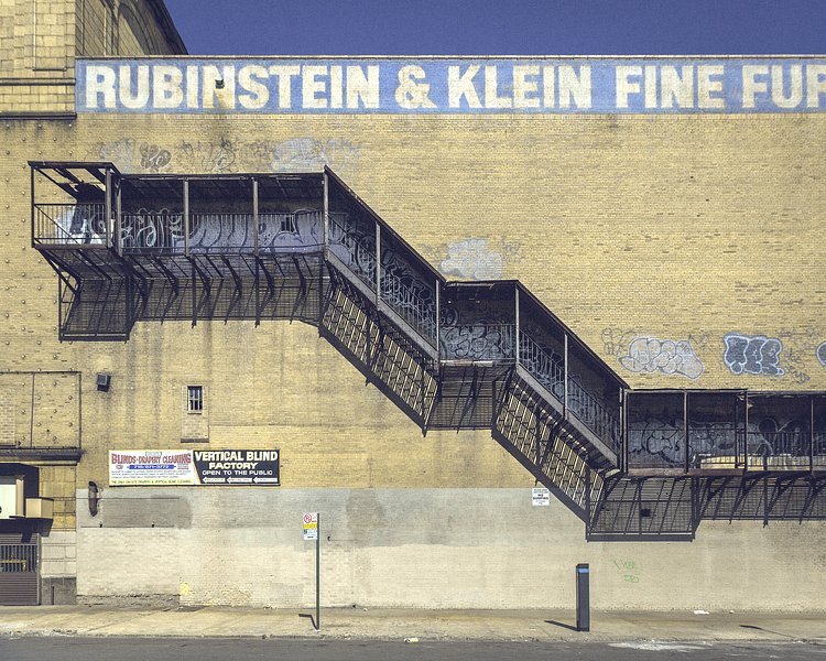 A fire escape like this one on a windowless structure is a sure sign that a building was once a movie theater.