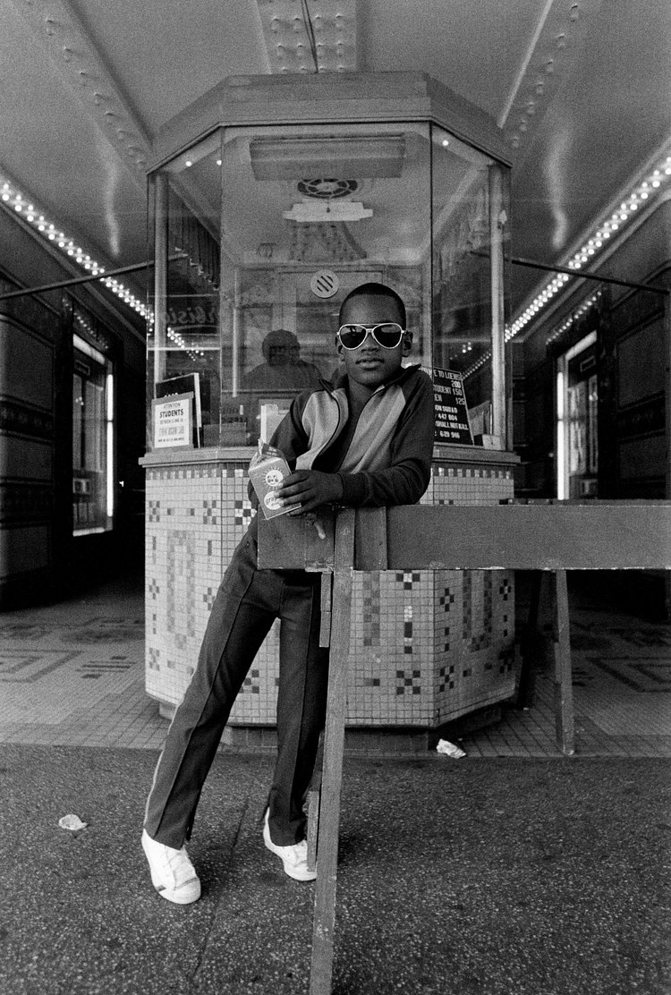 Boy in front of Harlem movie theater 1976