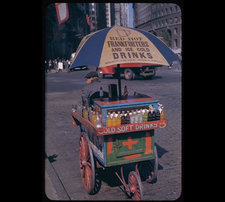 The hot-dog carts in New York City have only gotten bigger and more elaborate since 1942. Here, a vendor waits for business in Bowling Green.