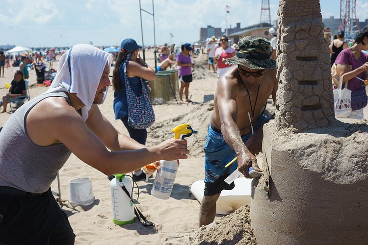 Spray | 8/20/2016 Sculptors wetting the sand at the Coney Island Sand Sculpting Contest. Sony a7. Carl Zeiss Planar 45mm 1:2.0.