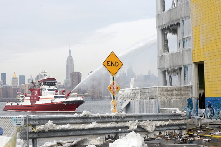 Firefighters continued pouring water on the remains of a 7-alarm fire in a warehouse on the Williamsburg waterfront