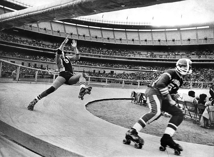 May 26, 1973: A roller derby triple-header at Shea Stadium involved contests between the Chiefs and the Bombers, the Pioneers and the Jolters, and finally the Chiefs and the Pioneers, in which the Chiefs prevailed. In this photo, a Jolter, left, struggled to keep his balance as Bob Hein of the Pioneers rolled past. “The fans hate me,” said Hein, who played with a broken cheekbone protected by a mask. “He had a fight and was penalized for ‘slugging,’”