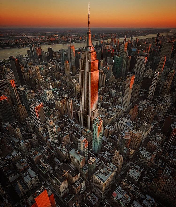 This is New York to me. Autumn winds from the open window, sirens below, you know that special smell when everything is possible? First orange dots on the trees outside, so you put a leather jacket on and head out. Elevator down, 'PLING,' one step out on the street. The flow of cars moving down, tourists moving up, and it's all about the music, so you turn it up and start walking with the beat. Like a music video, you know, don't pretend you haven't ever thought the same thing? It's like a big dirty orchestra, in perfect but rusty harmony... and beneath the stage the subway runs through its dark catacombs and shakes the ground. Here among you, the millions of dreamers are walking, running, talking on the phone with only their eyes meeting one another. One hundred floors of offices above, adding oil to this powerful machinery. You see beauty everywhere where others perhaps don't, like the red bricked alleys with graffiti and trash. You're feeling high from loving this city. You are part of it because it's now part of who you've become. You pass old restaurants you've never heard of, each a little dream of its own (and you imagine the work put into each handwritten menu). You can't help but to look in, couples holding hands, sharing a glass of wine, creations of food from all over the world at your display. You want go on a date with Derek and start all over again. You pass a small park with benches full of old men who exchanged their watches for paper-wrapped bottles a long time ago. You want to listen to their stories. At a red light, you look up and see the historic buildings reach for the old sky, and clouds reflecting in all that expensive glass and metal reaching for the new sky. You notice a silent jet plane cutting through the clouds. And you think: that was me arriving here - HOME - only 12 years ago. --- ❤️
Photo by Bruce Getty with my edit.