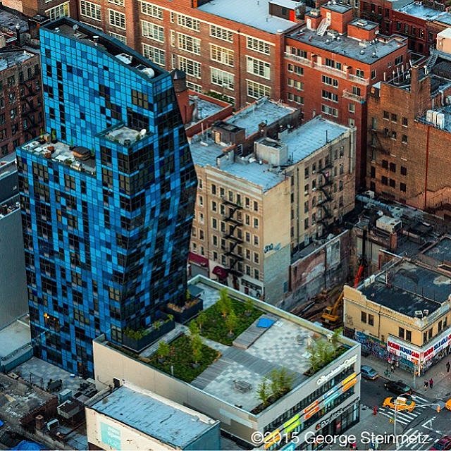 Photograph by George Steinmetz @geosteinmetz / @thephotosociety  Bernard Tschumi’s innovative 2007 BLUE residential tower on Manhattan’s Lower East Side uses angled walls and roof to allow for maximum floor space on the upper floors. BLUE introduced a new element to a neighborhood whose every-day character is expressed by the storefronts along Delancey Street.