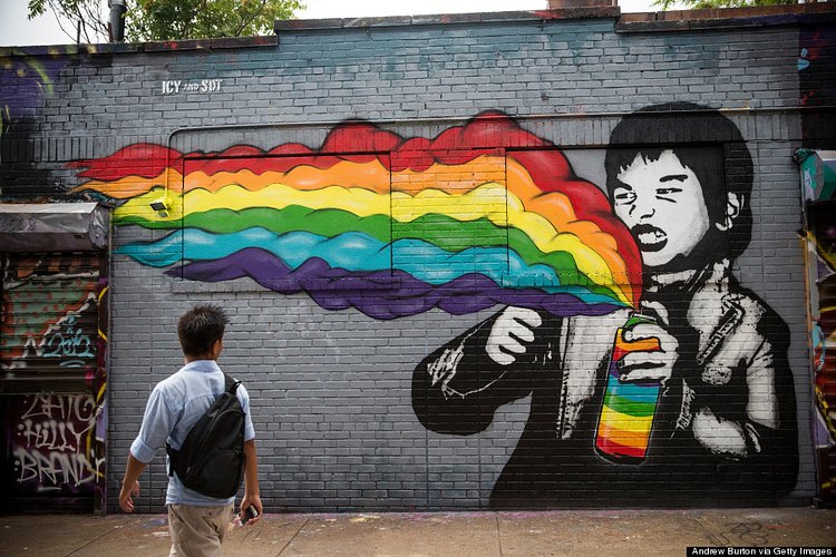 A man walks past a mural painted on the '5 Pointz' building on August 9, 2013 in the Long Island City neighborhood of the Queens borough of New York City.