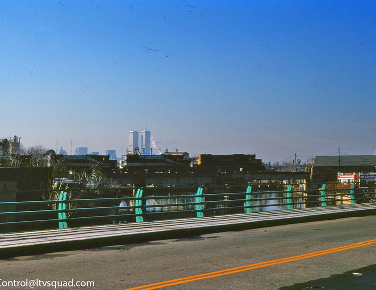 A string of 5 locomotives running northbound across M cabin drawbridge in the mid 1990s. Note the World Trade Center towers in the background – and the absence of the Greenpoint ‘digester eggs’. Also note the tour bus parking lot on the right (now a cement factory). To the left just out of view is where Seaporcel metals was located.