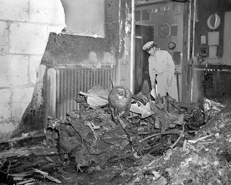 One of the bomber's motors, trailing part of the plane, crashed through two walls of the building, plummeted through roof and ended up burning in studio at 10 W. 33d St.
