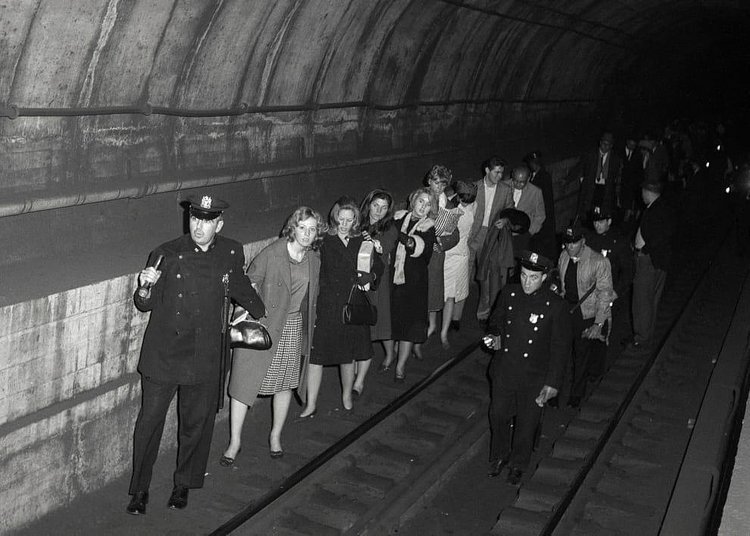 Police officers lead commuters through a subway tunnel where they were trapped during a power failure on Nov. 20, 1965.