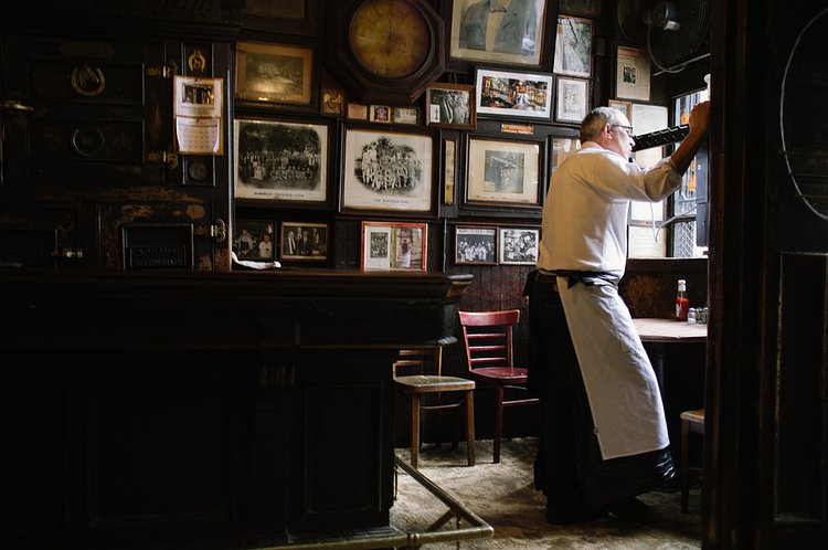 Bartender gazes out the window at McSorley's Old Ale House