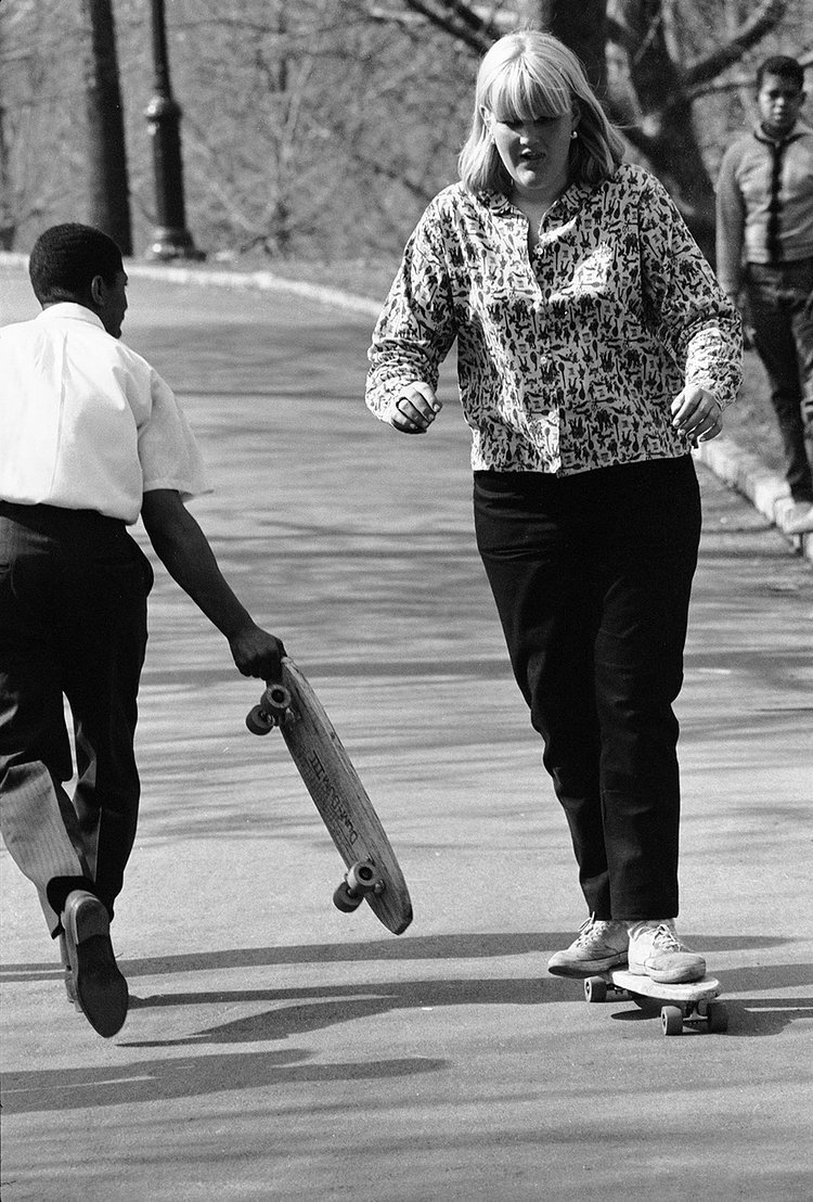 A girl wearing a shirt I wish I owned practices pushing in Central Park.