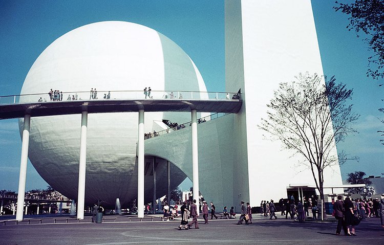 People visit the Trylon and Perisphere at the 1939 New York World's Fair. Inside the Perisphere was a diorama of a futuristic utopian city named Democracity. After viewing, visitors would leave by descending a long spiral walkway named the Helicline.