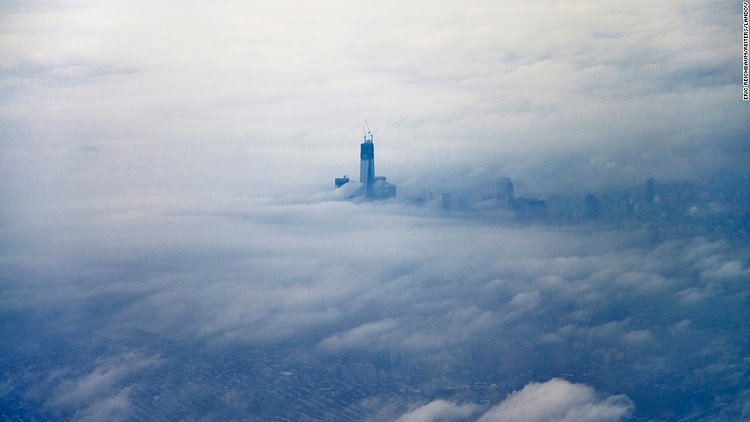 The newly constructed One World Trade Center building, dubbed "Freedom Tower," rises above the clouds on December 2, 2012, in an aerial photo taken from an airplane leaving New York's LaGuardia Airport. 