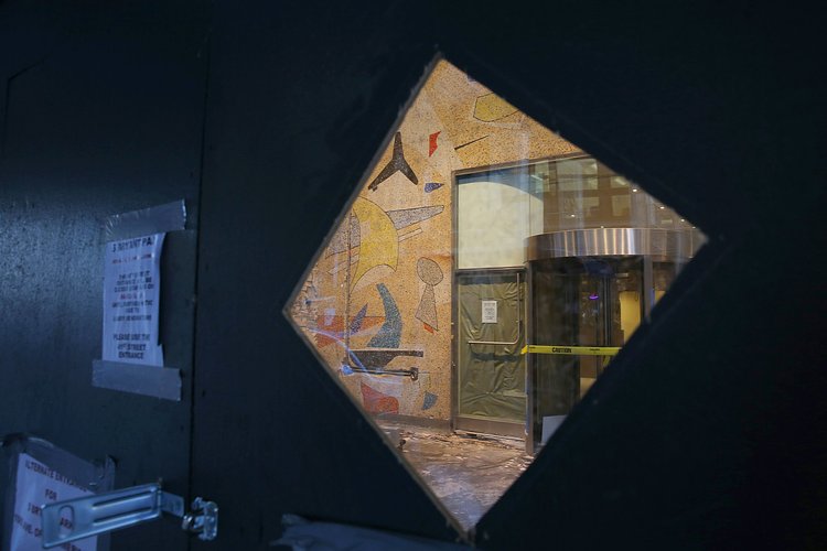 The mural seen through a clear panel in a construction wall.