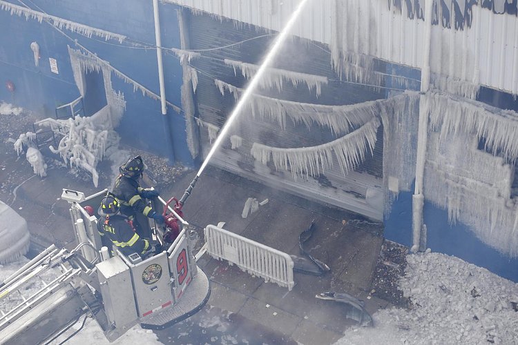 Firefighters continued pouring water on the remains of a 7-alarm fire in a warehouse on the Williamsburg waterfront