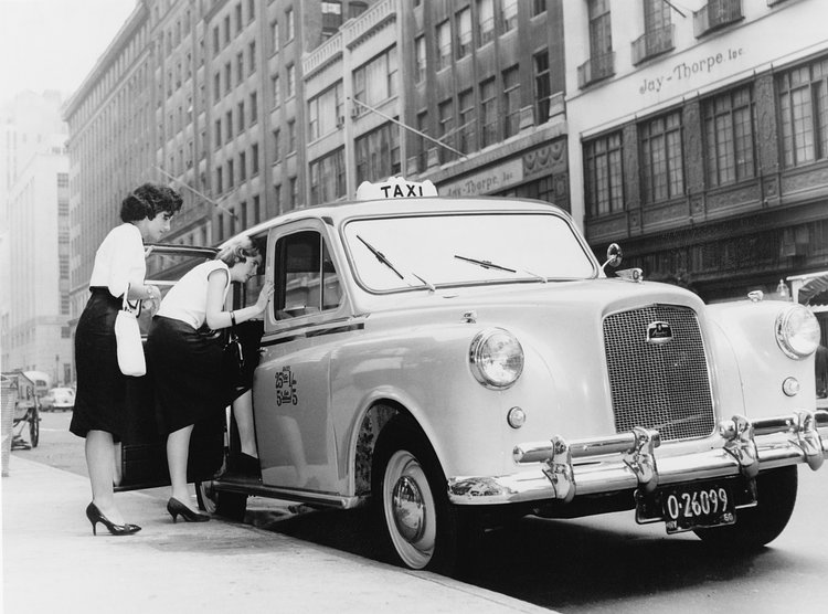 Two women getting into the first British-built Austin taxi licensed in New York, 1960.