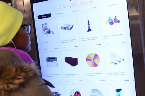 Subway Rider Browsing Holiday Gift Guide on On The Go Kiosk