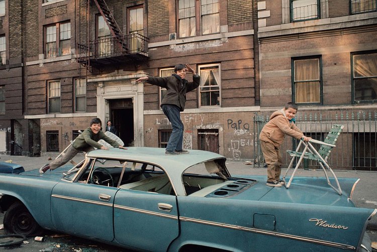 Kids playing on an abandoned car in South Bronx, 1970