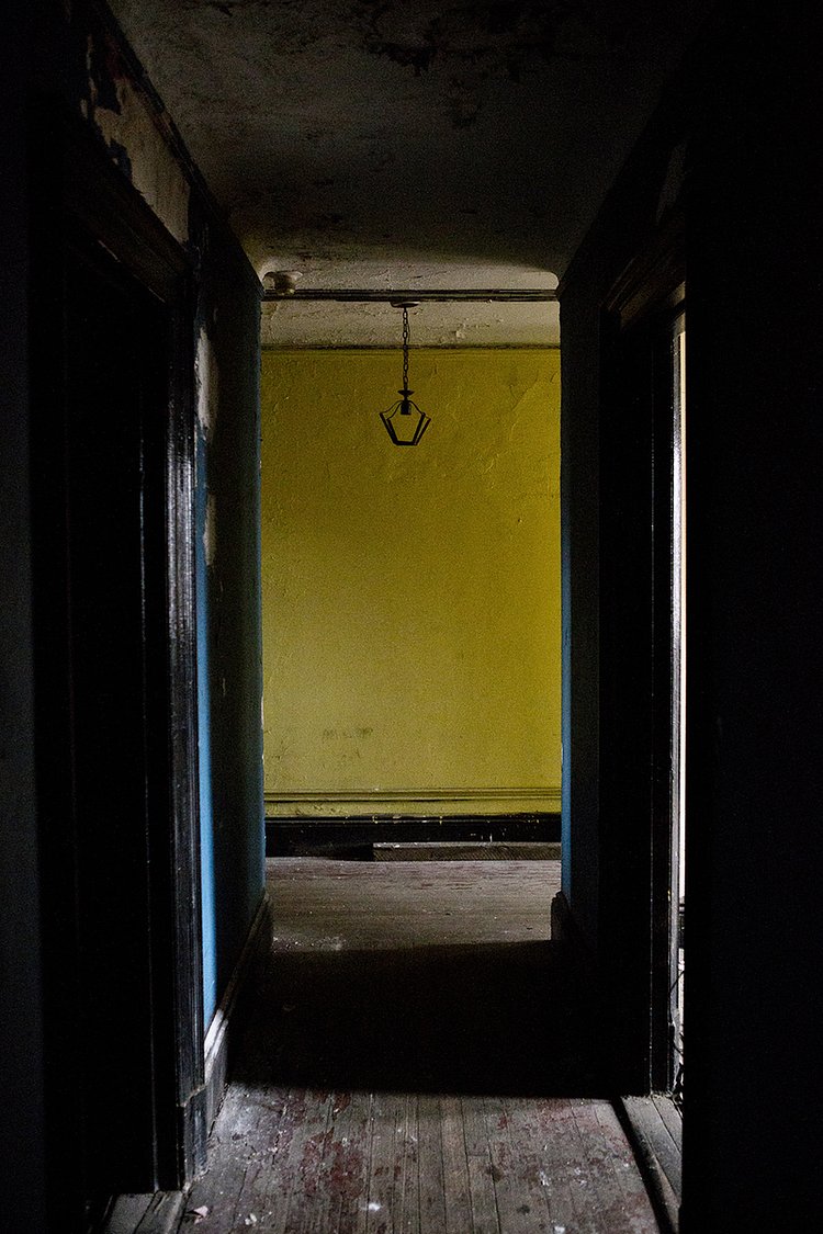 Inside the apartment, looking past the living room and kitchen doors.