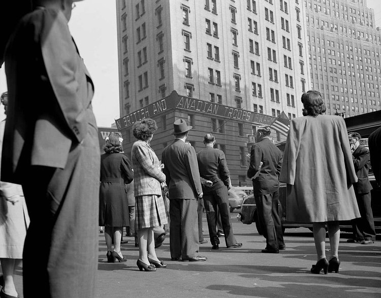People gather in Times Square to watch the news ticker on the New York Times building