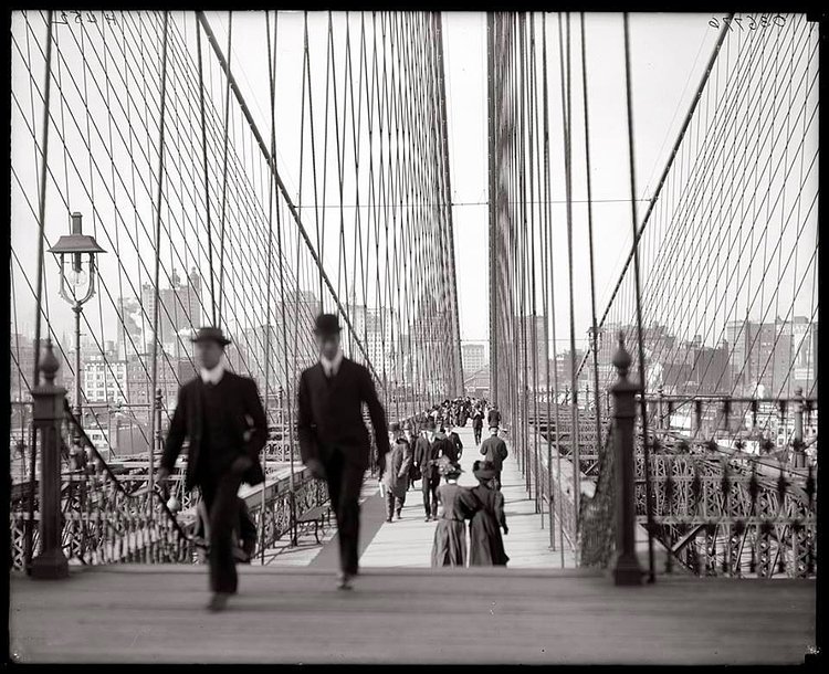 Dapper men and elegant women crossing Brooklyn Bridge, 1910