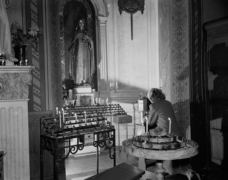 A woman prays at St. Vincent de Paul’s church on 23rd Street