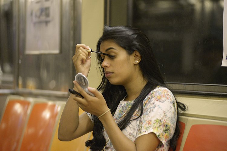 Woman Applying Mascara on Subway