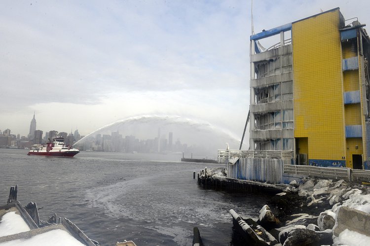 Firefighters continued pouring water on the remains of a 7-alarm fire in a warehouse on the Williamsburg waterfront