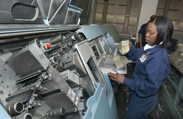 A Money Room employee uses the GPS 1000 high speed mixed currency counter and sorter to process 30 bills per second, 2006.