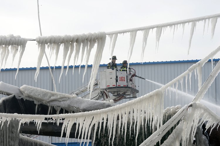 Firefighters continued pouring water on the remains of a 7-alarm fire in a warehouse on the Williamsburg waterfront