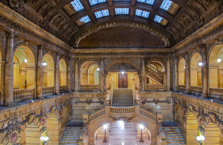 Originally intended to replace City Hall (the idea was scrapped after a public outcry), the building was constructed on a monumental scale. The lobby is all marble— Siena for the walls, pink and beige for the floor— as is the arcaded, colonnaded lobby a floor above.