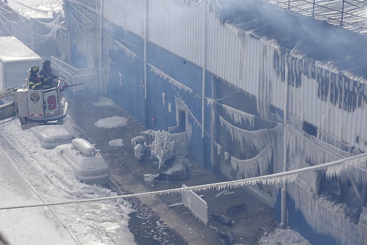 Firefighters continued pouring water on the remains of a 7-alarm fire in a warehouse on the Williamsburg waterfront
