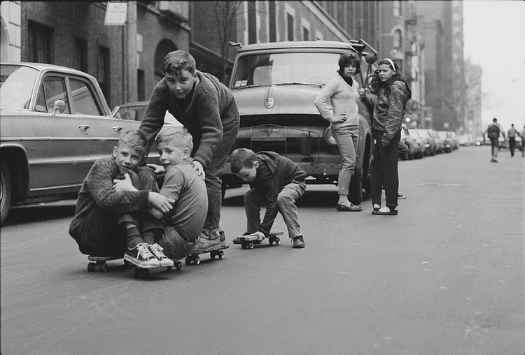 A group of friends gets creative in the streets while ladies throw shade in the background.
