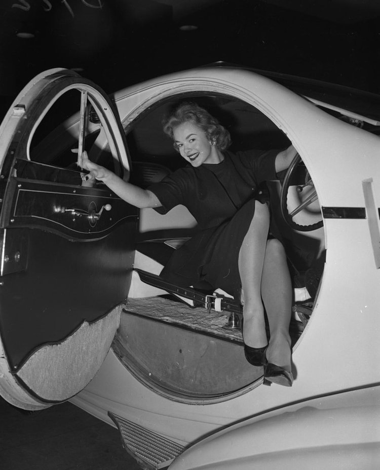 "Notice those lines? It's really a dream. Every man should have one. It's the $100,000 Rolls-Royce sports car. Oh, the girl? She's model Marjorie Holler," read the original Daily News caption for this photo from the Motor Sports Show.