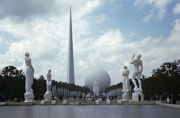A row of statues leads to the Perisphere and Trylon.