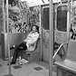 1980's: The writing's on the wall: A tired passenger rests while seated in an empty, graffiti-filled subway car in 1980.