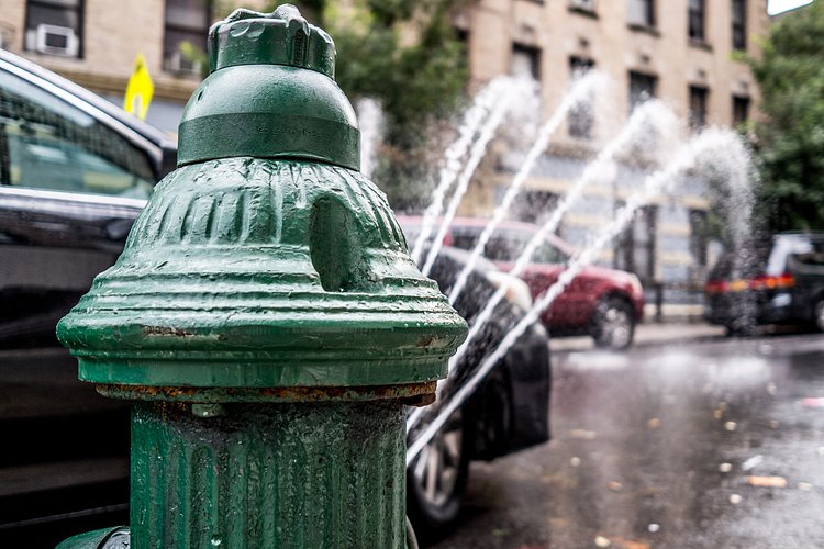 Classic NYC Summer | An open hydrant spraying water on a hot summer day.