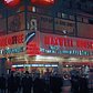 1946 The neon-illuminated Maxwell House and Mayflower Doughnuts coffee shop at the north-west corner of the busy intersection of West 42th Street (which runs left to right) and Broadway.