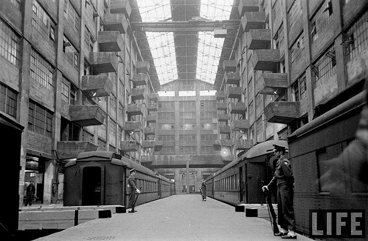 Here's what it looked like in action. There were cranes, not visible here, that picked cargo directly off the trains and placed it onto the balconies so that it could be loaded directly onto the proper floor. The balconies were staggered so the cranes could access each one.